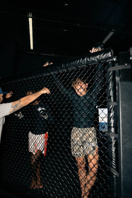 Athletes watching training from the edge of The Q MMA cage