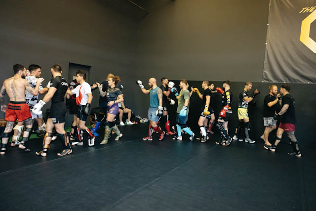 Team Naccache gathered together at the end of training beneath The Q MMA logo